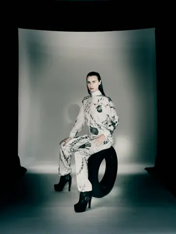 Model standing in white tyre-printed jumpsuit on runway