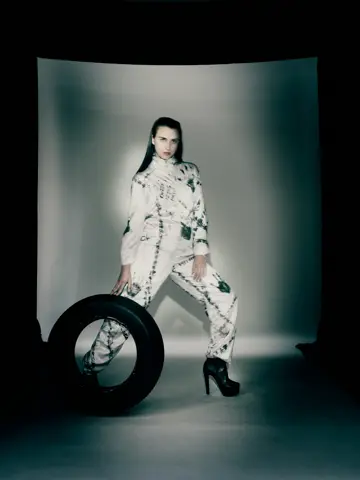 Model seated on a tyre wearing the tyre-printed jumpsuit