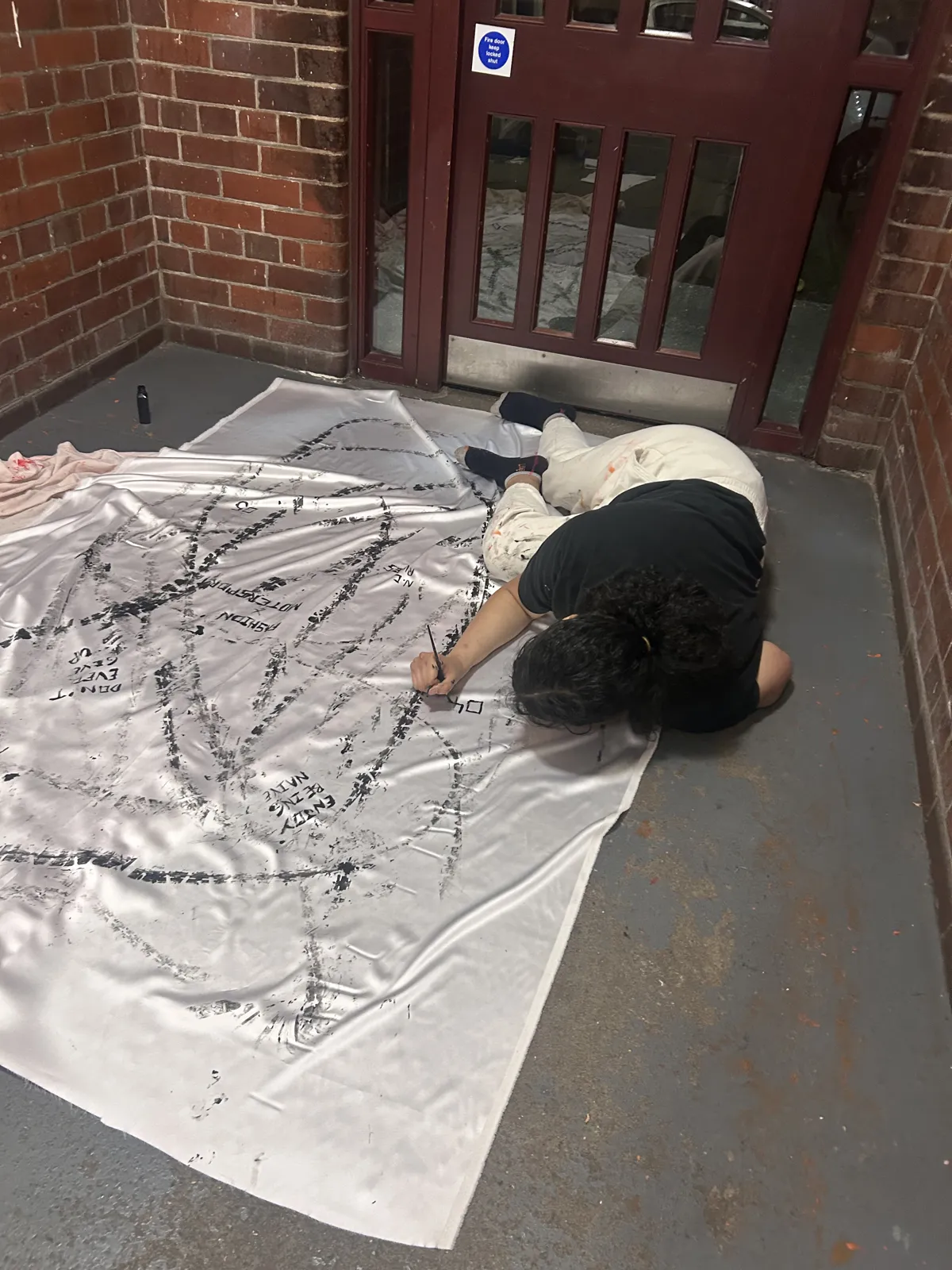 Nelliza at work, rolling a painted tyre across fabric