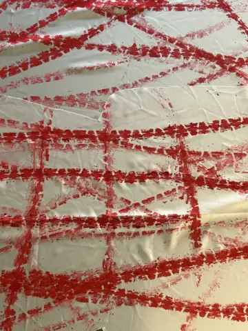 Red tyre tracks crossing white fabric
